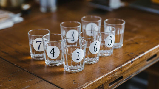 8 numbered glasses of water on a table