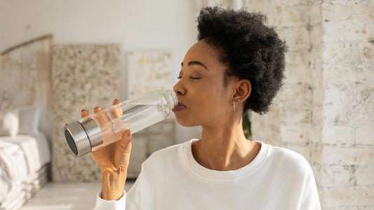 woman tasting water from a hydrogen water bottle